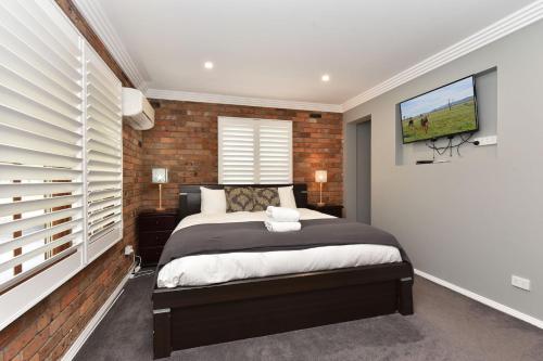 a bedroom with a bed with a brick wall at Kitchener Country Estate with Pool Hot Tub on private acres that sleeps up to 18 in Kitchener