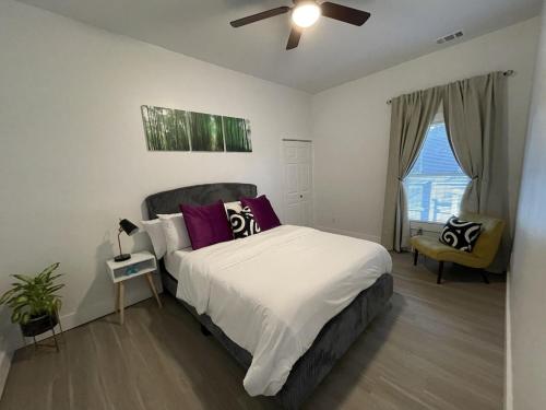 1 dormitorio con 1 cama con almohadas moradas y blancas en City Serenity-2BR Home away from Home. 6 Min from ATL Airport, en Atlanta