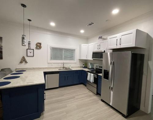 a kitchen with blue cabinets and a stainless steel refrigerator at City Serenity-2BR Home away from Home. 6 Min from ATL Airport in Atlanta
