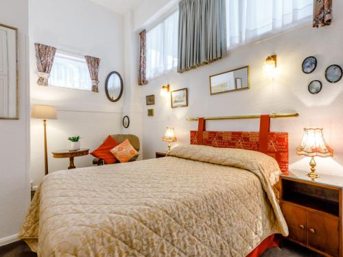 1 dormitorio con 1 cama grande y algunas ventanas en Clooneavin Apartment 2, en Lynmouth