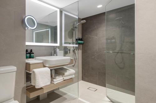 a bathroom with a shower and a sink at Crowne Plaza Hawkesbury Valley, an IHG Hotel in Windsor