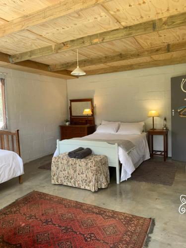 a bedroom with two beds in a room with a wooden ceiling at Shabach Farm in Hartebeest Rivier