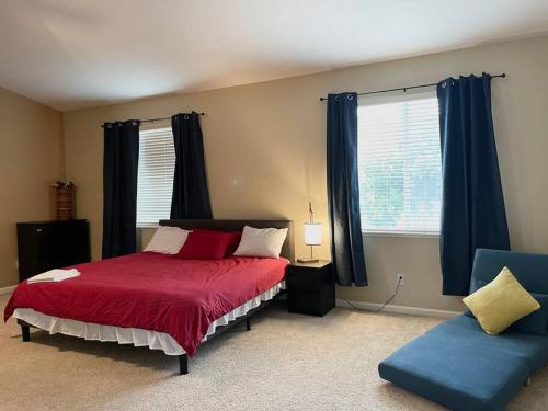 1 dormitorio con 1 cama roja y 1 silla azul en LAKE view Elk Grove house 3300 sqf 5 bedrooms, en Elk Grove