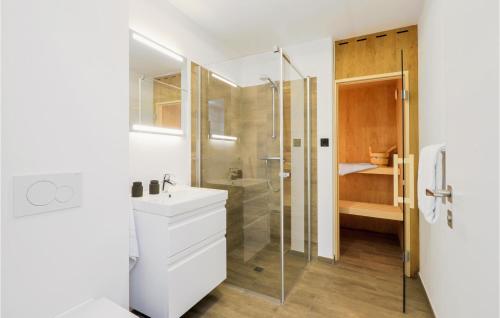 ein weißes Bad mit einer Dusche und einem Waschbecken in der Unterkunft 2 Bedroom Stunning Home In Lembruch-dmmer See in Lembruch