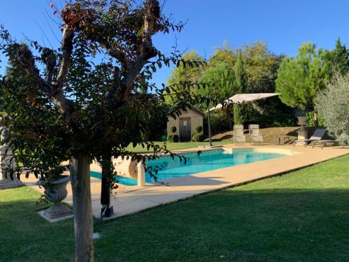 een zwembad in een tuin met een boom bij Amity. Exclusive poolside garden apartment in Sarlat-la-Canéda