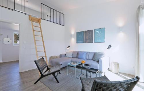 a living room with a blue couch and a ladder at Nice Home In Lembruchdümmer See in Lembruch