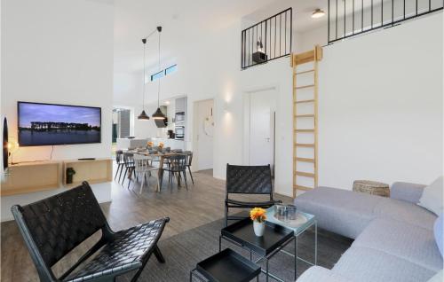 a living room with a couch and a table with chairs at Nice Home In Lembruchdümmer See in Lembruch