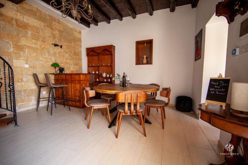 a dining room with a wooden table and chairs at VINGT-DEUX Vouni 22 in Vouni