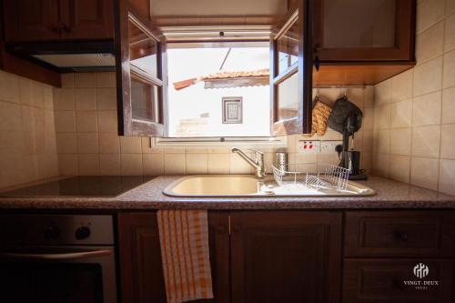 a kitchen counter with a sink and a window at VINGT-DEUX Vouni 22 in Vouni
