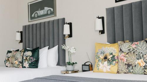 a hotel room with a bed with two pillows at The Selwyn, Richmond in Richmond upon Thames