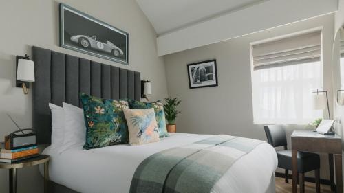 a bedroom with a bed with a tv on the wall at The Selwyn, Richmond in Richmond upon Thames