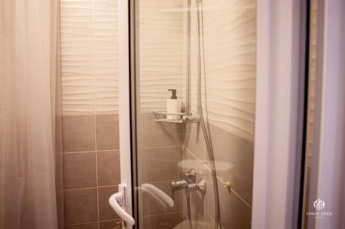 a shower with a glass door next to a toilet at VINGT-DEUX Vouni 22 in Vouni