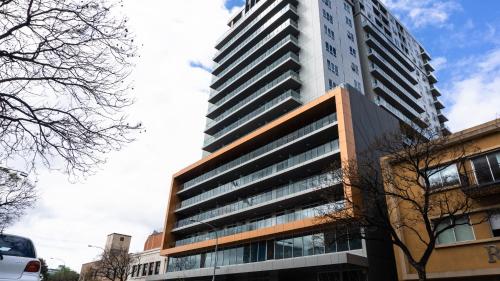 a tall building in the middle of a city at Tasha's Apartments on Morphett in Adelaide