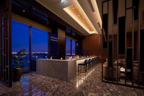a bar in a restaurant with a view of the city at Villa Fontaine Premier Haneda Airport in Tokyo