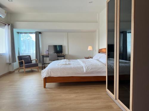 a bedroom with a bed and a desk and a chair at 92 Chiangrai poshtel in Ban Fang Min