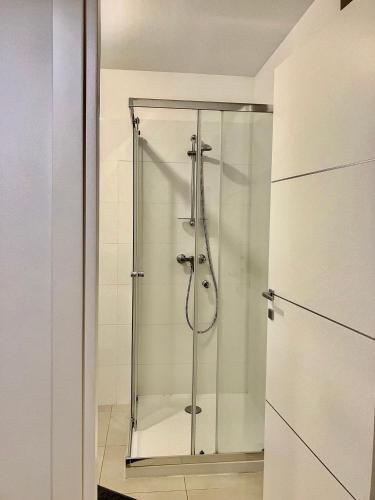 une douche avec une porte vitrée dans une salle de bain dans l'établissement Domaine a Mortella, à Saint-Florent