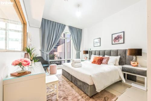 een slaapkamer met een bed en een groot raam bij bnbmehomes - Duplex Living walk to Burj K and Dubai Mall - L313 in Dubai