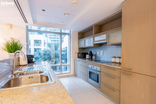 a kitchen with a sink and a large window at bnbmehomes - Duplex Living walk to Burj K and Dubai Mall - L313 in Dubai