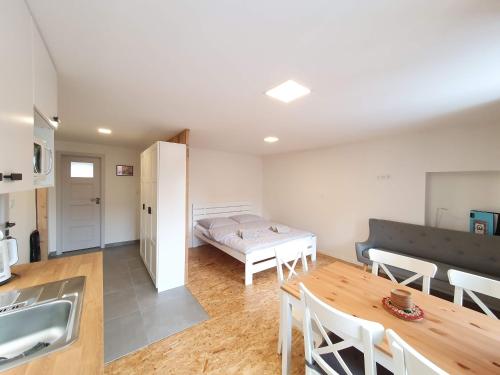 a kitchen and dining room with a bed and a table at Apartmány U Muzea in Horní Blatná