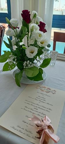 a table with a vase of flowers and a note at Hotel Ascot Riccione in Riccione