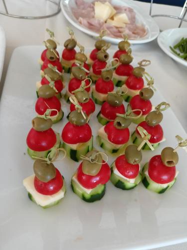 a plate of appetizers with apples and mushrooms on them at Hotel Ascot Riccione in Riccione