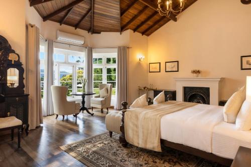 a bedroom with a large bed and a fireplace at The Lavender House by Reveal in Kandy