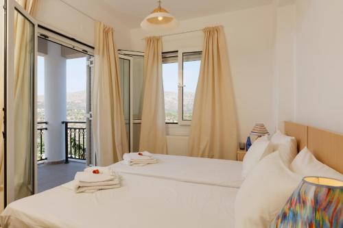 a bedroom with two beds and a large window at Marakis Villas in Kavrokhórion