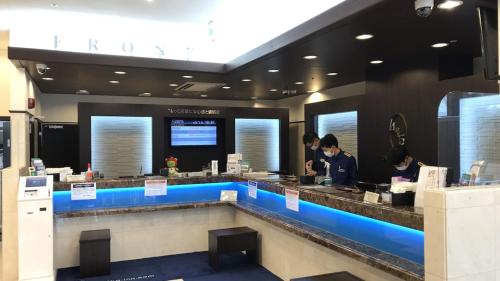 un restaurante con dos personas preparando comida en un mostrador en Toyoko Inn Matsumoto eki Higashi guchi, en Matsumoto