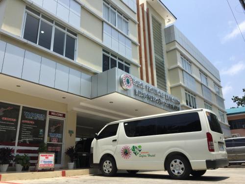 uma carrinha branca estacionada em frente a um edifício em BOPEMPC Safari Hostel em Tagbilaran