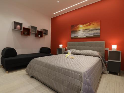 1 dormitorio con 1 cama grande y 1 sofá en Borgo Alto B&B, en Boscotrecase