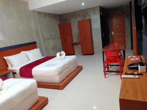a hotel room with two beds and a desk at La Gensol Plaza Hotel in Mamburao
