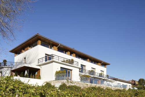 un bâtiment blanc avec un toit dans l'établissement Hotel San Prudentzio, à Getaria