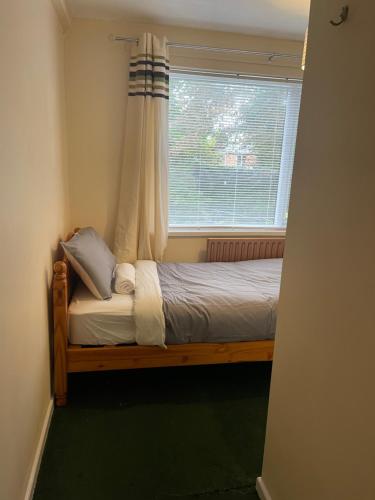 ein kleines Bett in einem Zimmer mit Fenster in der Unterkunft The Swan Inn in Henwick