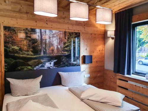 Zimmer mit einem Bett und einem Gemälde an der Wand in der Unterkunft StrandBerg's Harzchalet in Braunlage