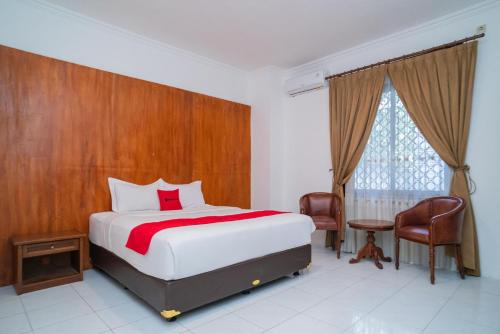 a bedroom with a bed and a table and a window at RedDoorz Plus at Hotel Surya Solo in Solo