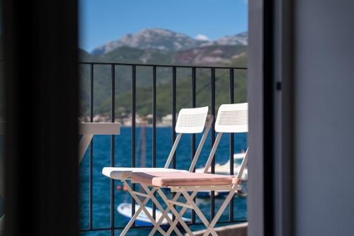 two chairs sitting on a balcony overlooking the water at Villa Lastva in Tivat