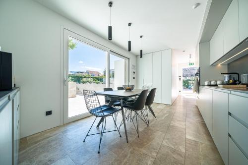 a kitchen and dining room with a table and chairs at Villa Lastva in Tivat