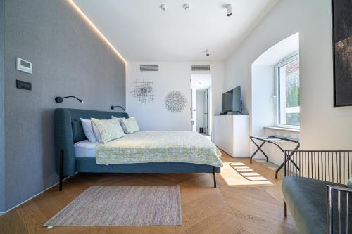 a bedroom with a blue bed and a living room at Villa Lastva in Tivat