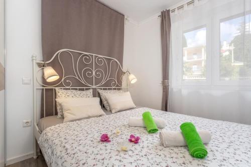 een slaapkamer met een bed met twee groene handdoeken erop bij Apartment in Njivice with sea view, balcony, air conditioning, WiFi (4930-2) in Njivice