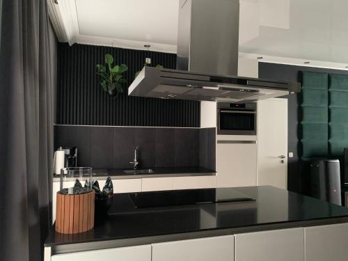 une cuisine avec une cuisine noire et blanche dans l'établissement Lans Apartments SPA Menden Sauerland, à Menden