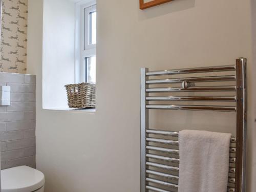 a bathroom with a toilet and a towel rack at North Road Cottage in Hackforth