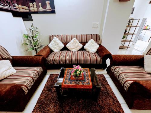 a living room with two couches and a coffee table at Cozy 2BHK condo surrounded with greenery. in Mangalore