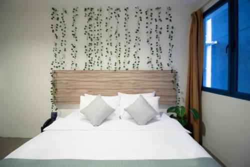 a bedroom with a bed with white sheets and a window at Victoria Hotel a NuVe Group Collection in Singapore