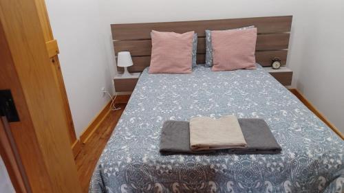 a bedroom with a bed with two pillows and two towels at Lisbon Rossio Typical Apartments in Lisbon