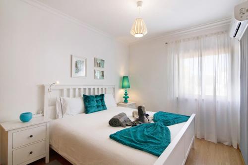 ein Schlafzimmer mit einem Bett mit einem Teddybär drauf in der Unterkunft Santa Luzia Apartment Sl016 in Santa Luzia