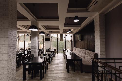 a dining room with tables and chairs and windows at Brooklyn in Yablunytsya