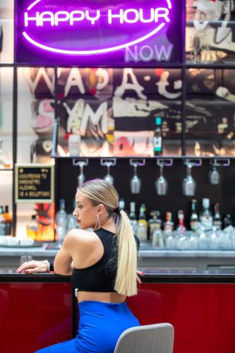 a woman sitting at a counter in a bar at T62 Hotel in Budapest