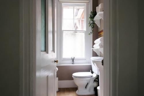 a bathroom with a toilet and a window at Contemporary 2 Bedroom Flat in Lewes in Lewes