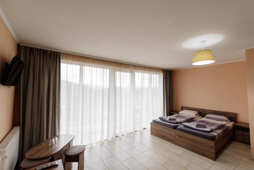 a bedroom with a bed and a large window at Brooklyn in Yablunytsya