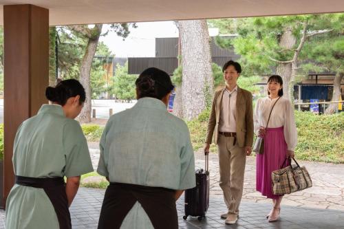 a group of people standing in front of a building at Hotel Hagoromo in Shizuoka